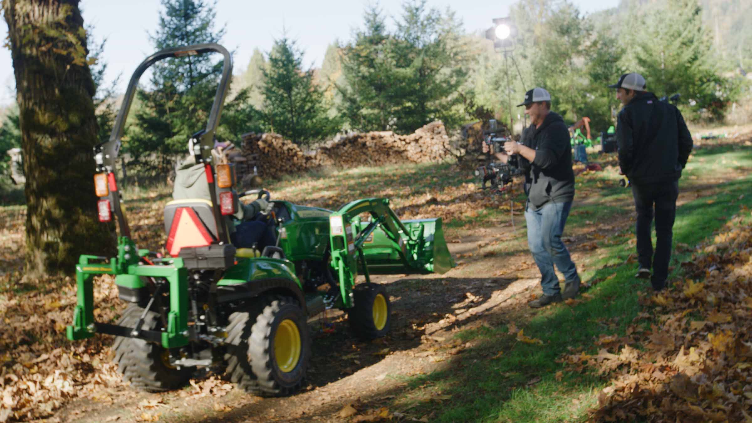 Film crew shooting tractor in woods