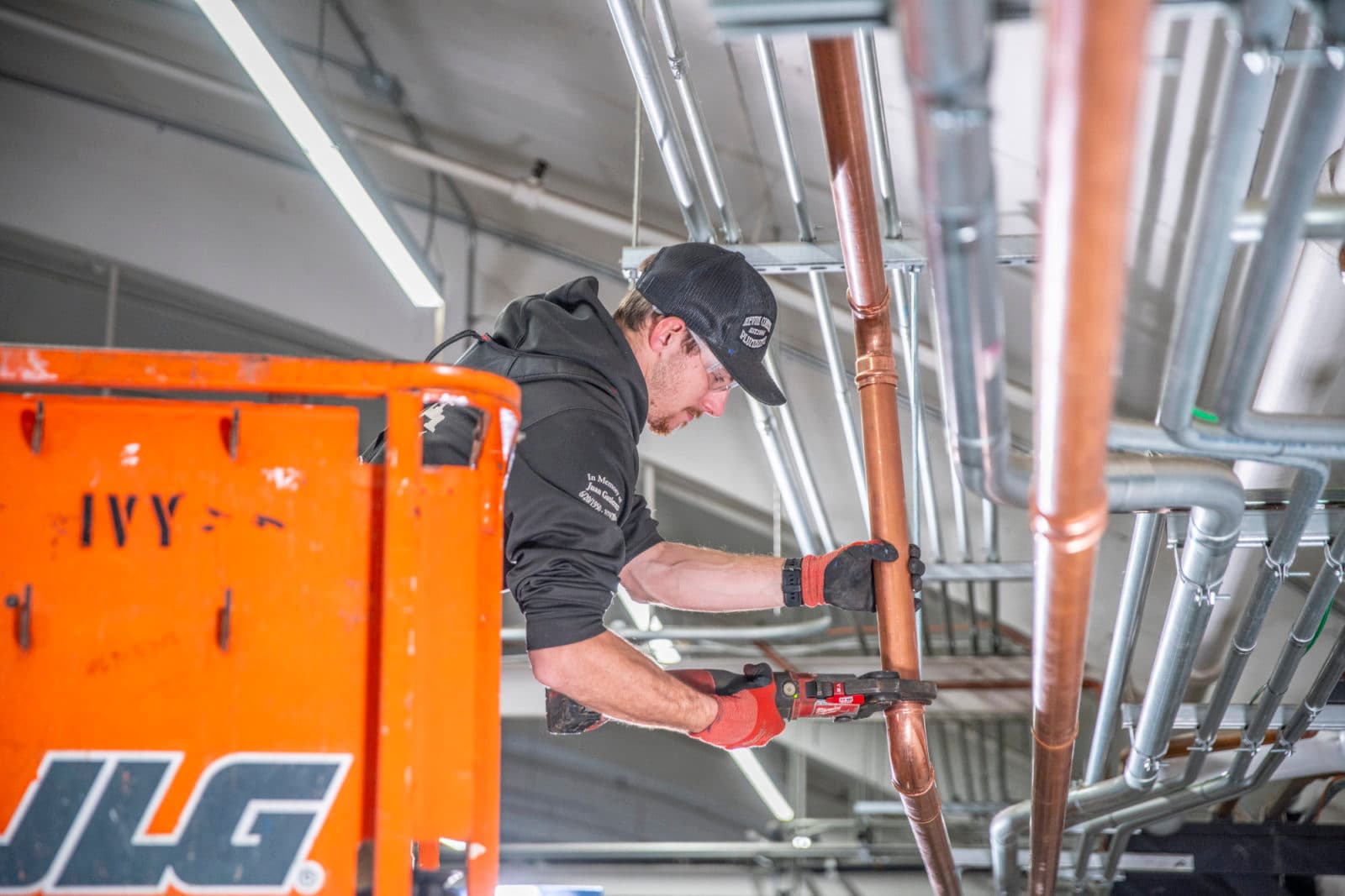 Plumber on JLG lift fitting copper pipe