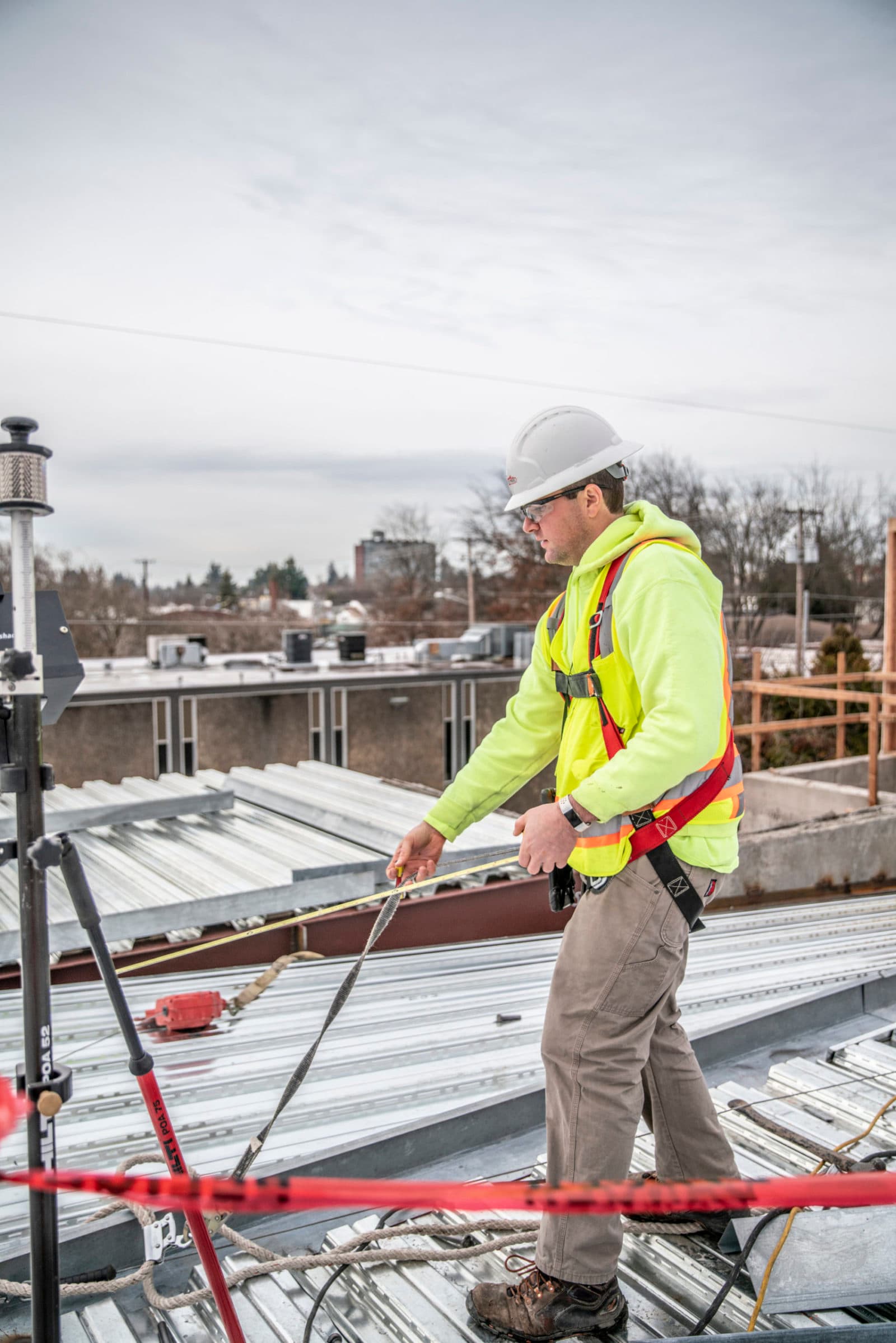 Harnessed worker on roof deck (portrait)