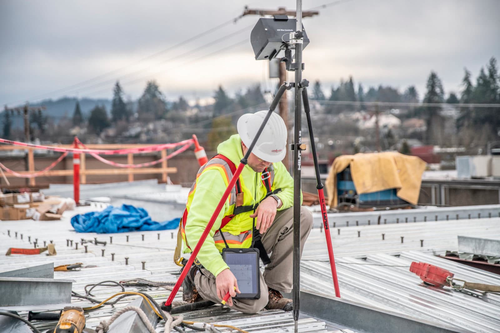 Surveyor with GPS tripod on roof deck