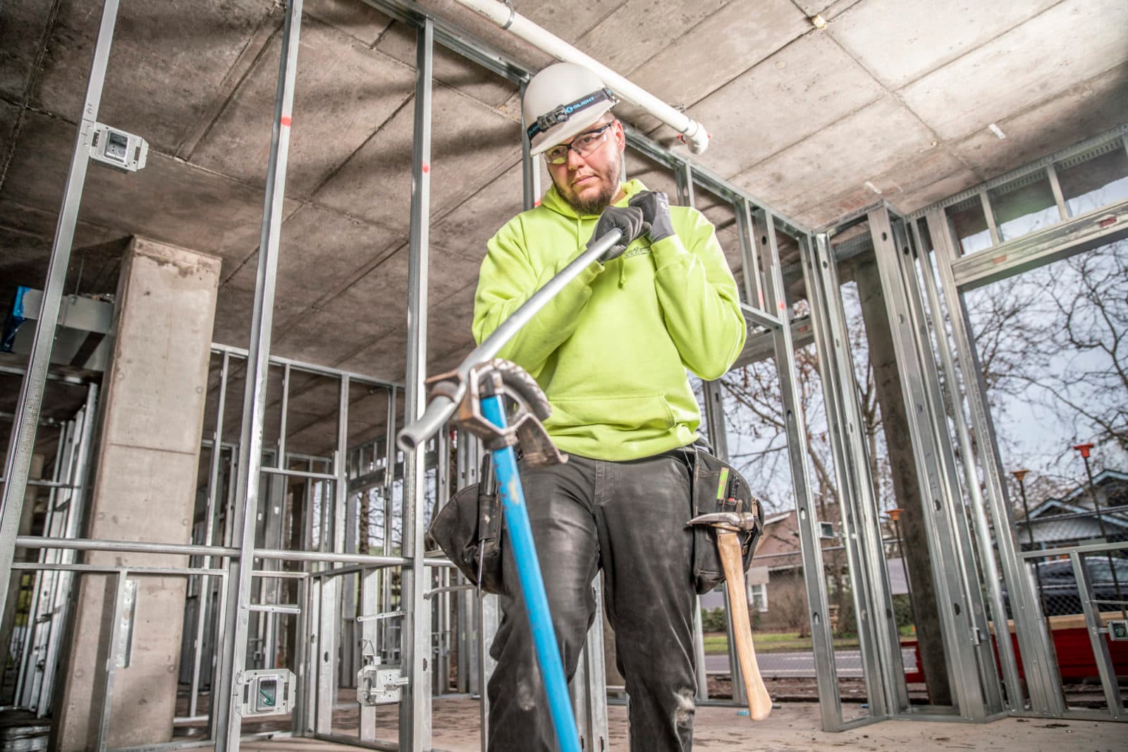 Electrician pulling conduit in steel-stud framing