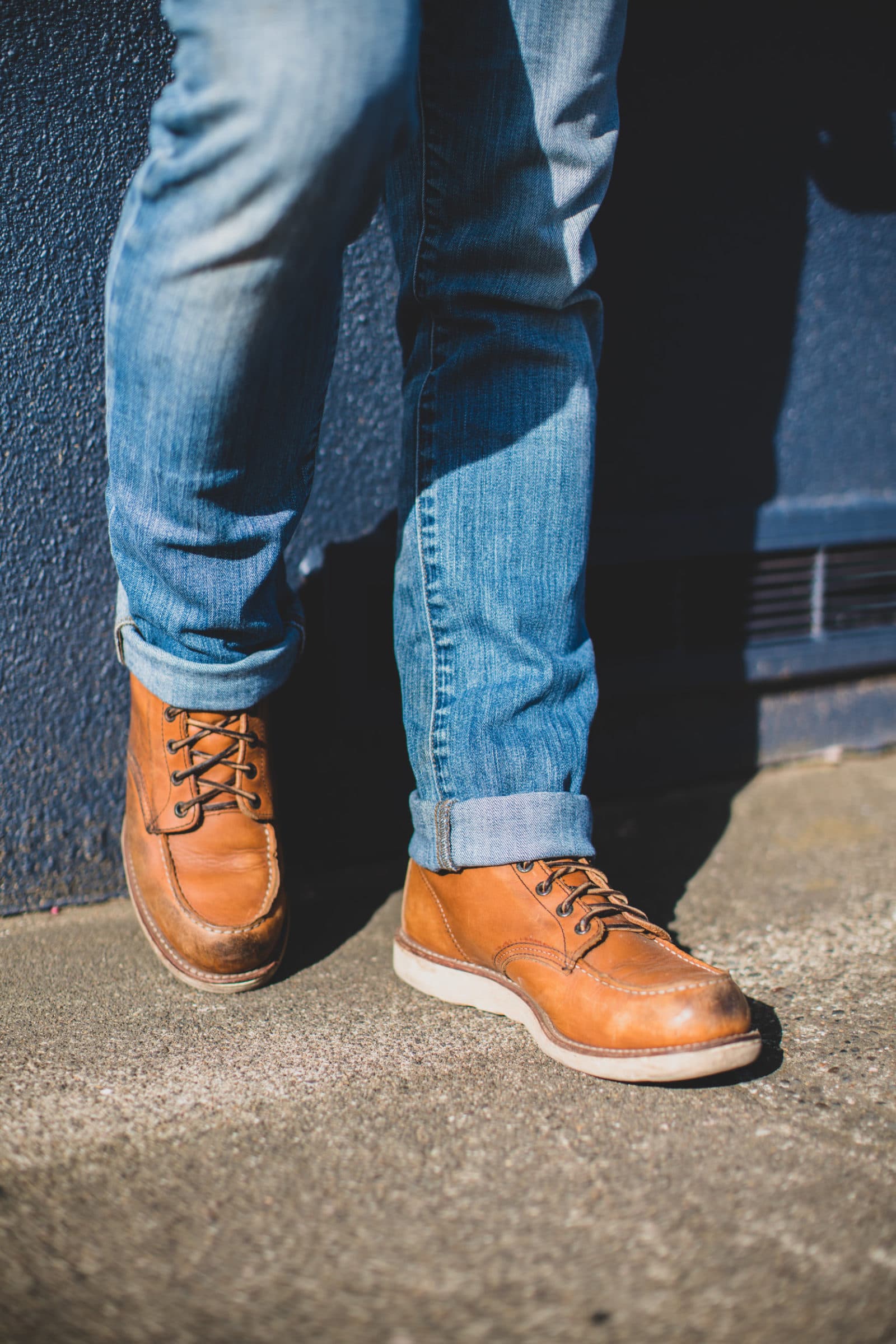 Tan moc-toe boots with rolled jeans (portrait)