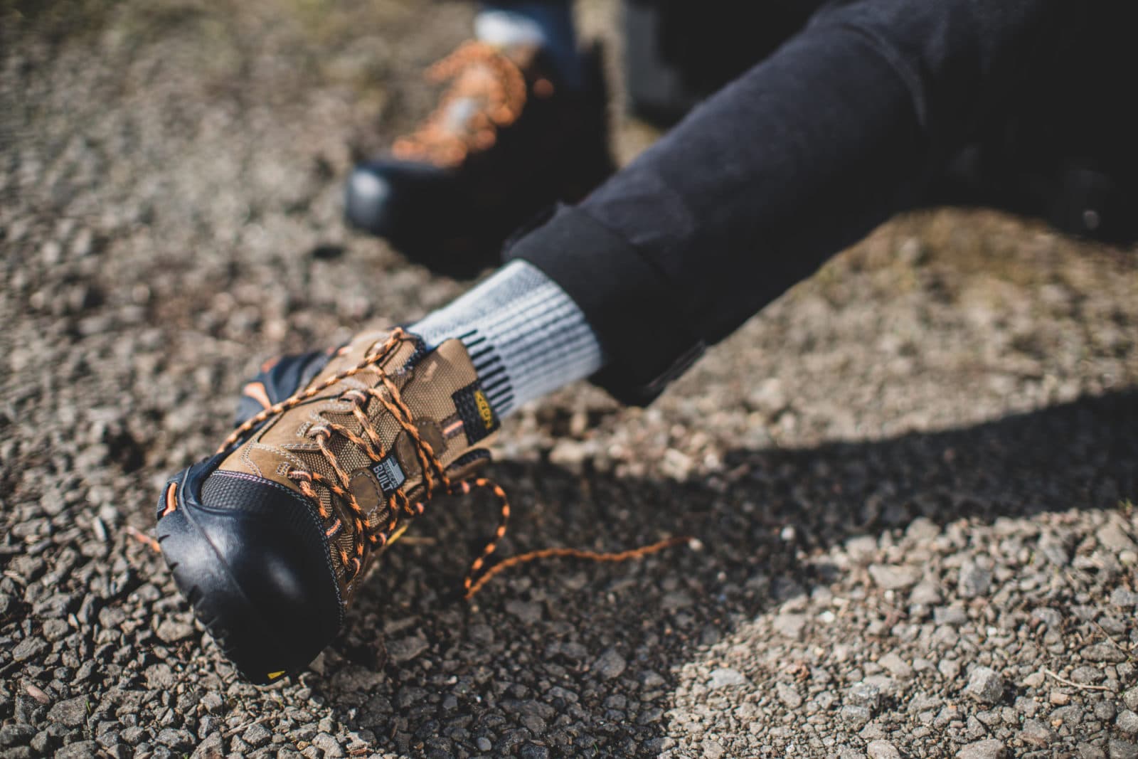 Black leather hiking boot on gravel