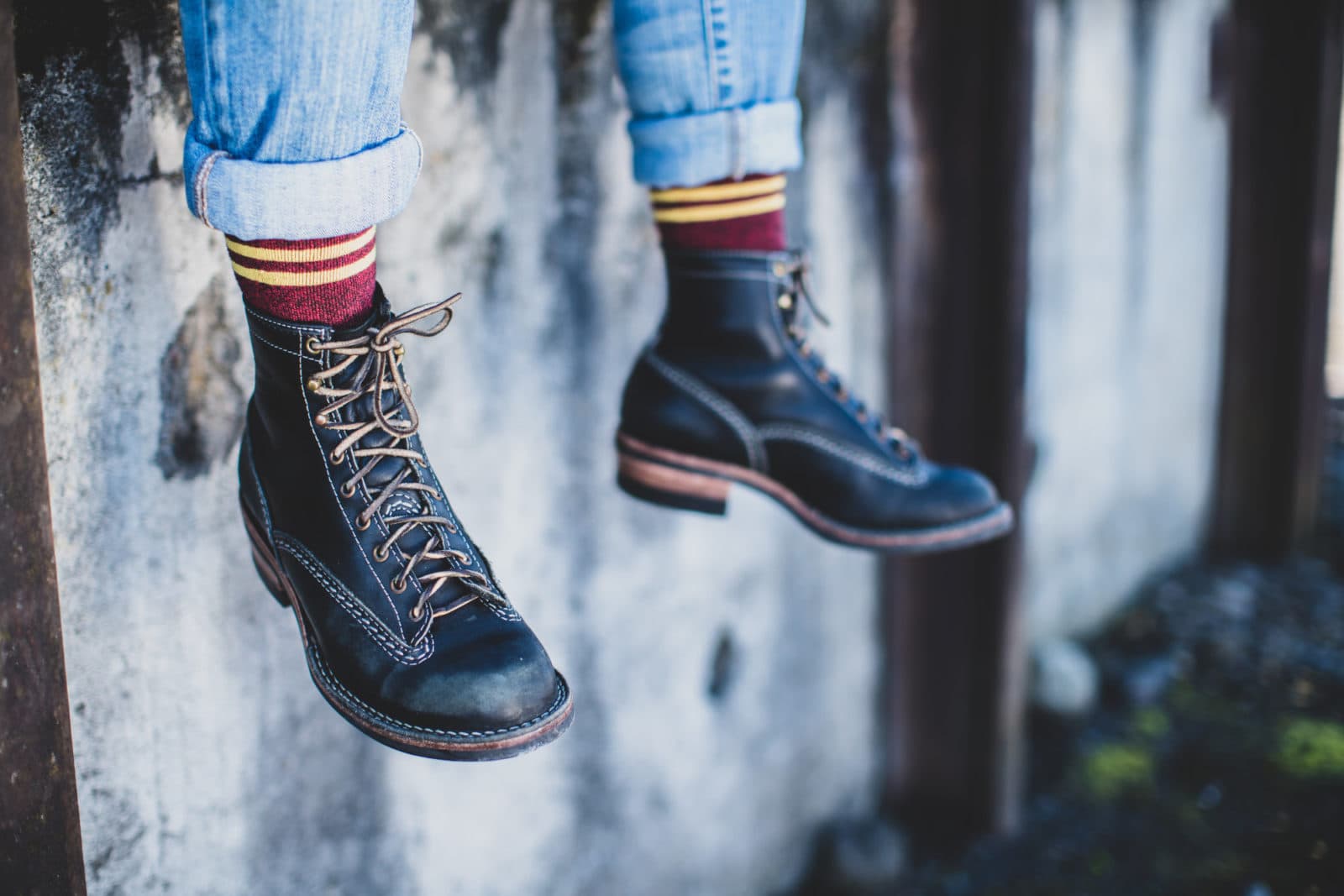 Dangling legs in black lace-up boots