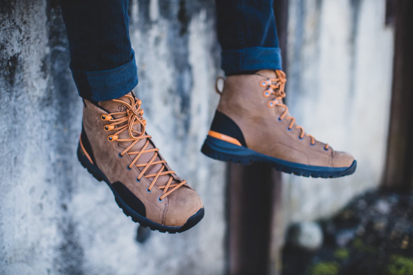 Hiking boots dangling against weathered wall
