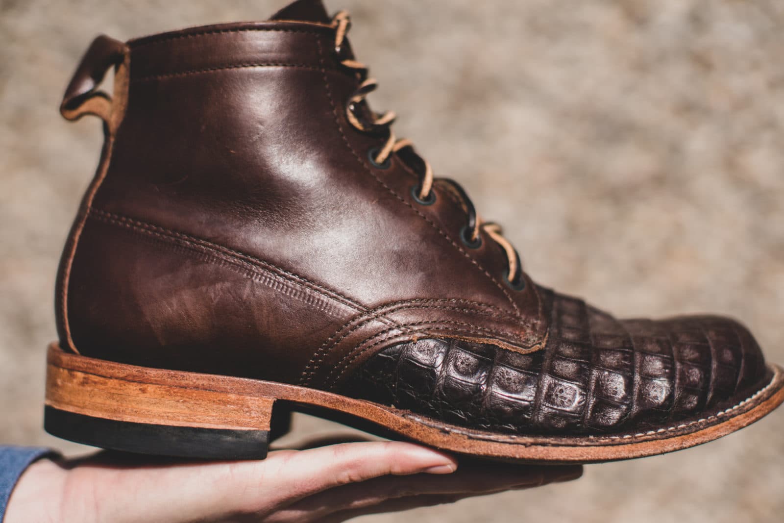 Brown leather boot held on palm