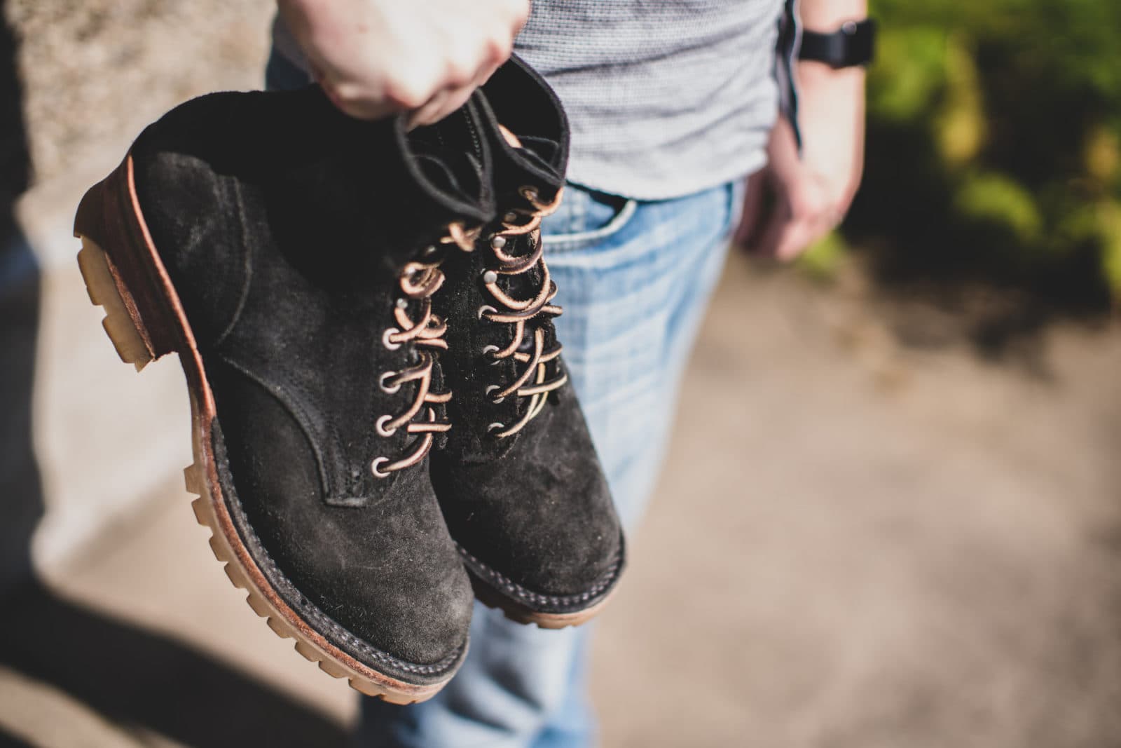 Black suede boots held by the laces