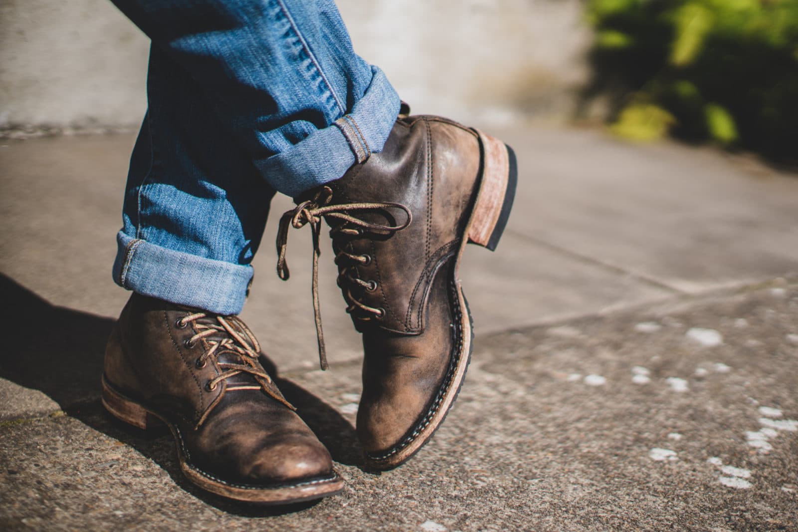 Worn brown leather boots and cuffed jeans