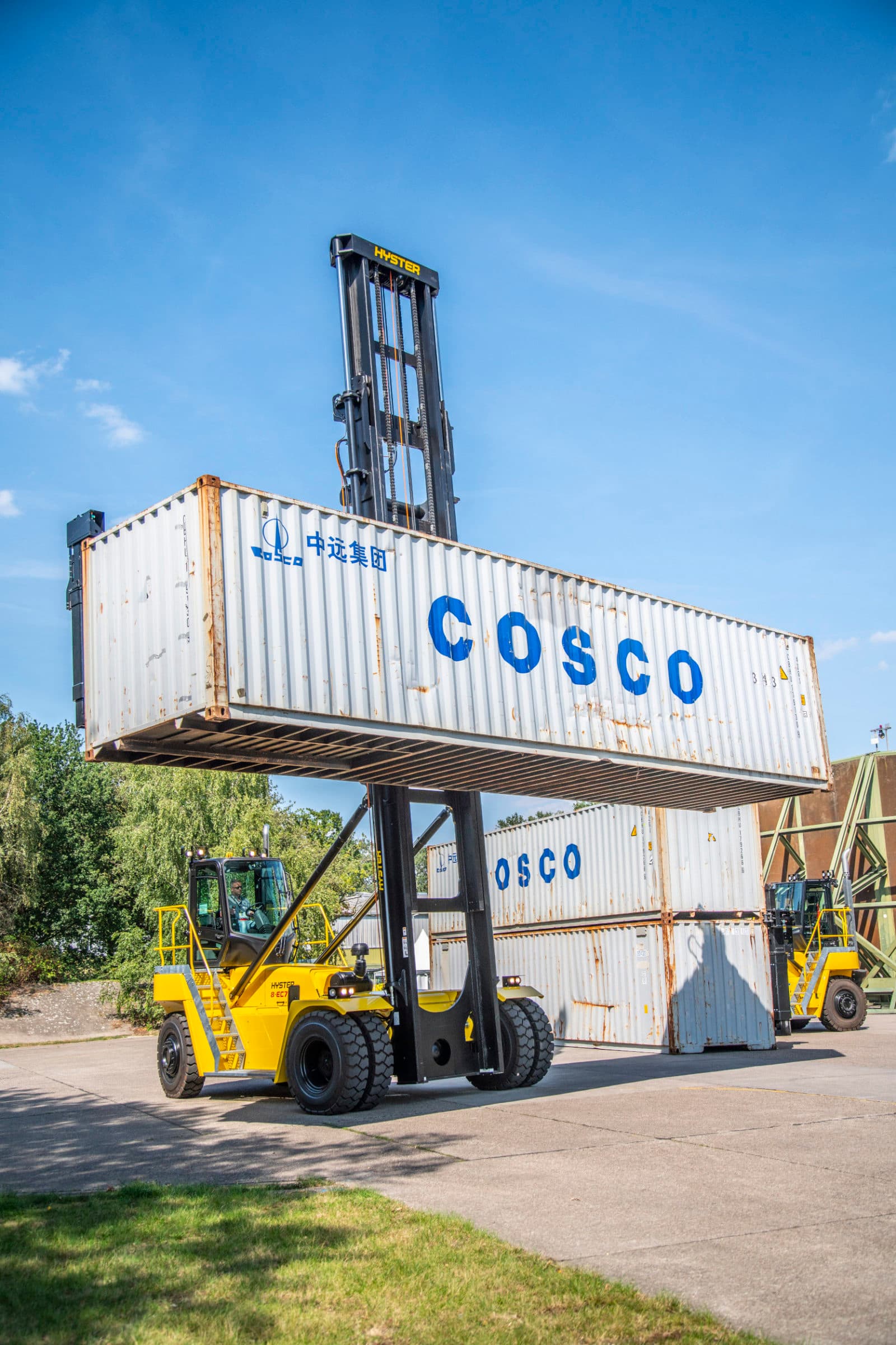 Hyster handler lifting COSCO container, blue sky