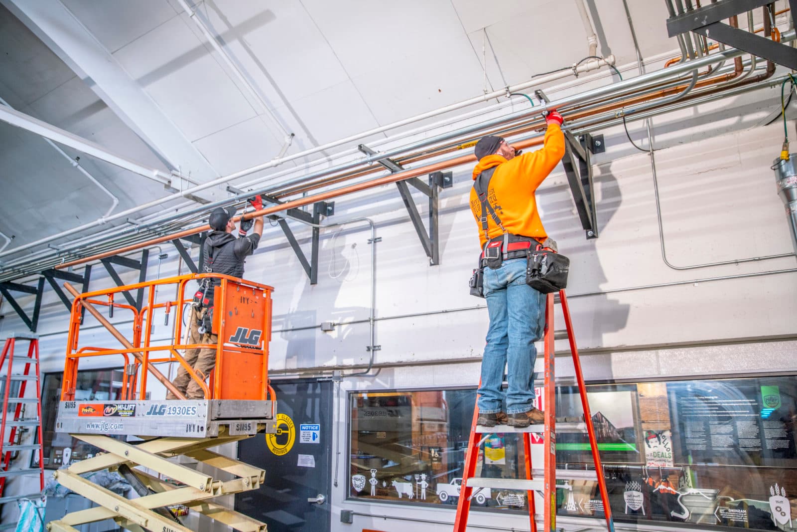 Crew on scissor lift and ladder at ceiling