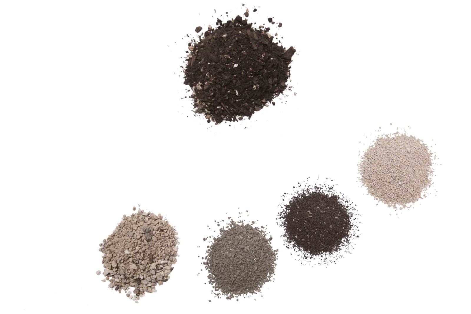 Five soil sample piles on white