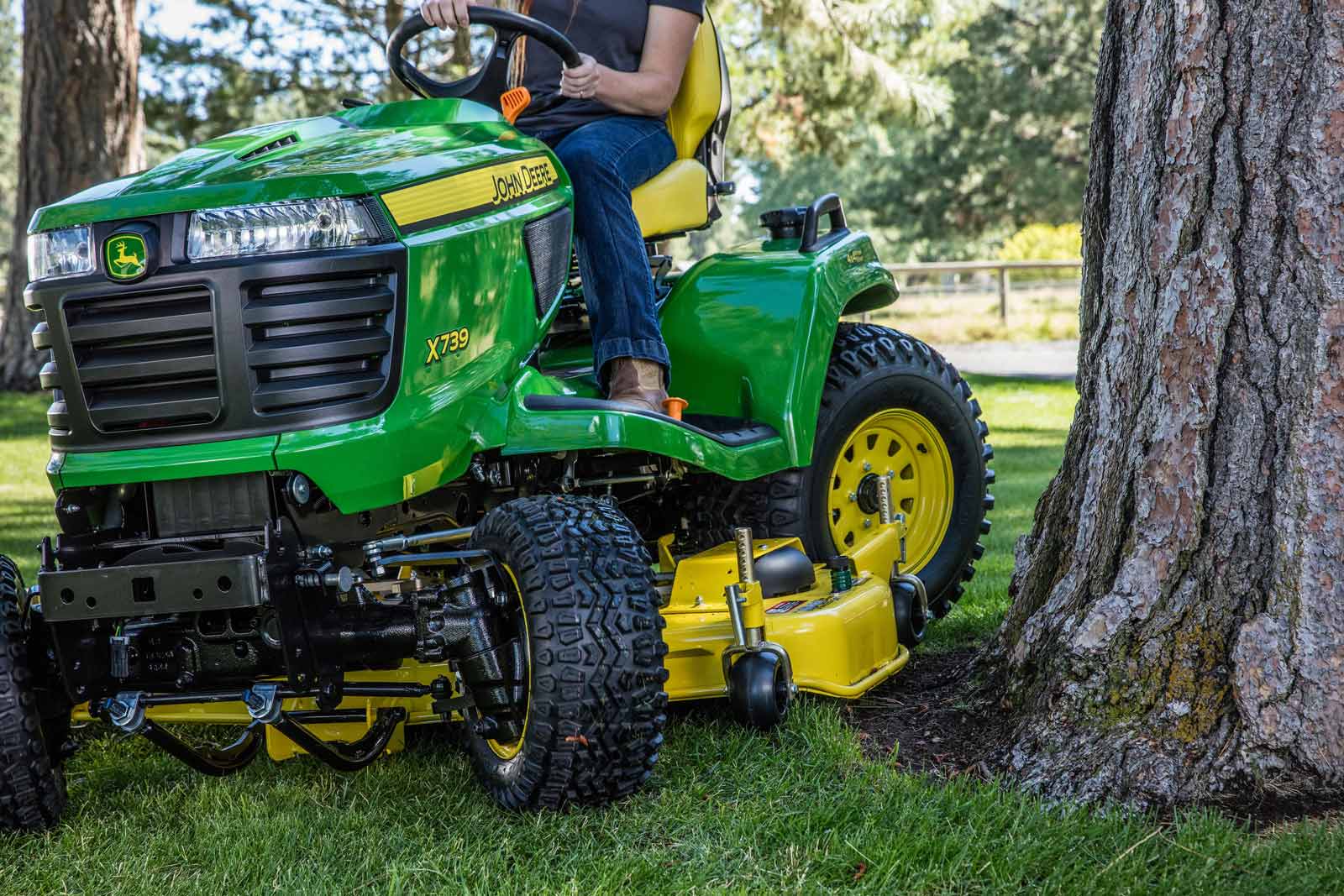 John Deere X739 riding mower by tree