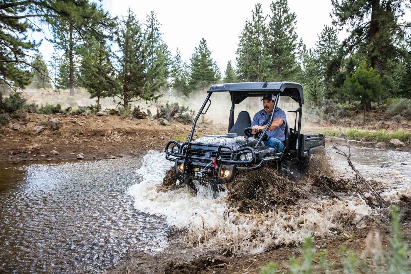 John Deere Gator splashing through creek