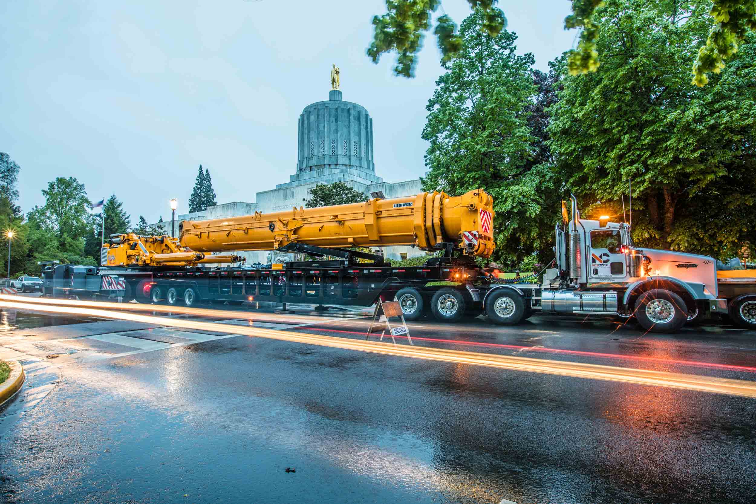 Heavy-haul crane truck at Oregon Capitol, dusk