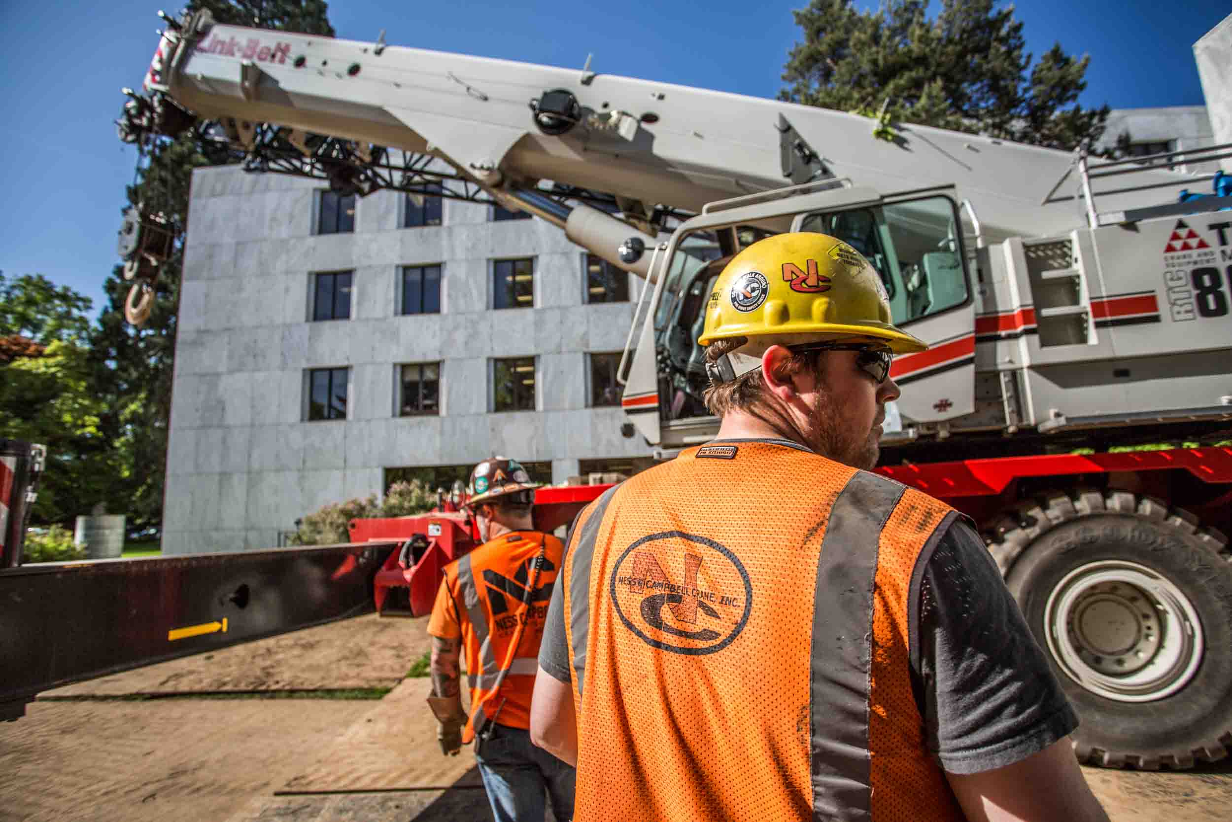 Rigger in hard hat beside mobile crane