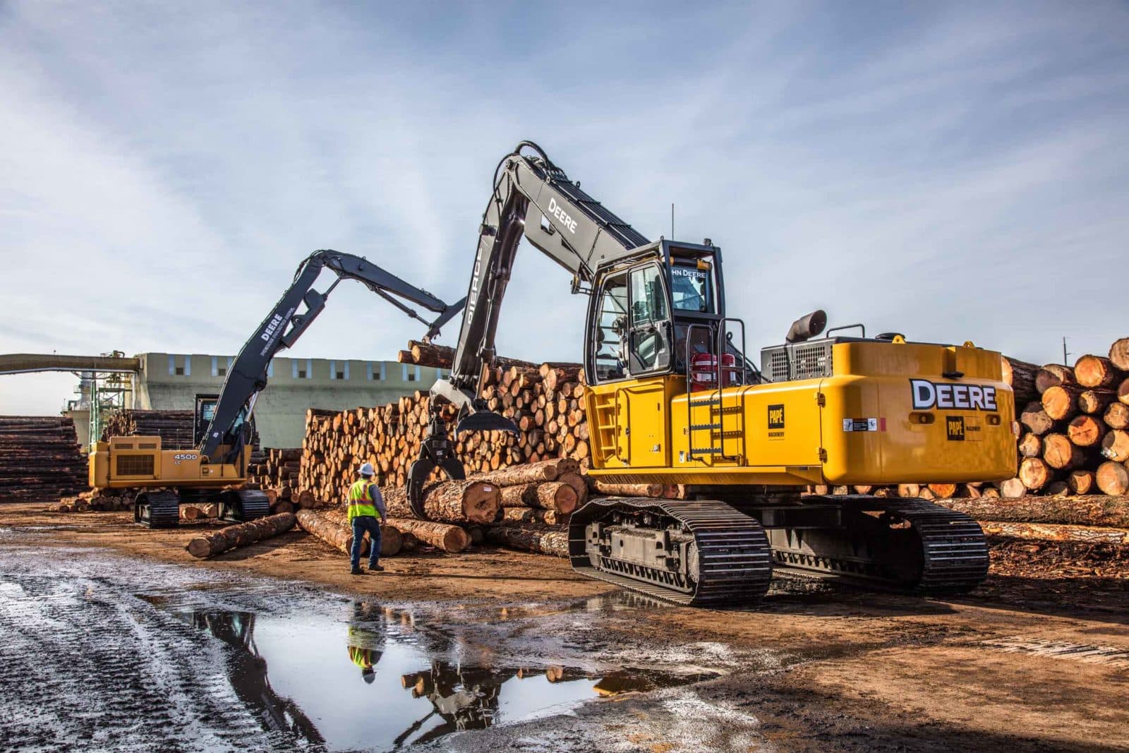 John Deere log loader in muddy log yard