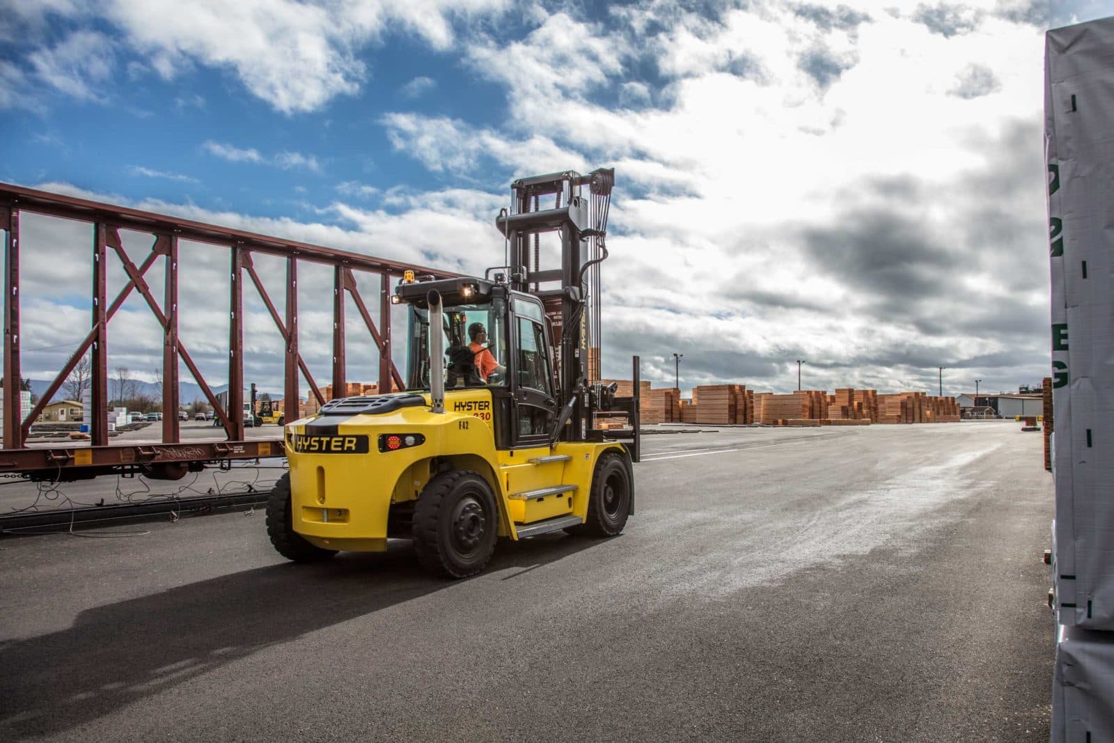 Big forklift driving past rail cars