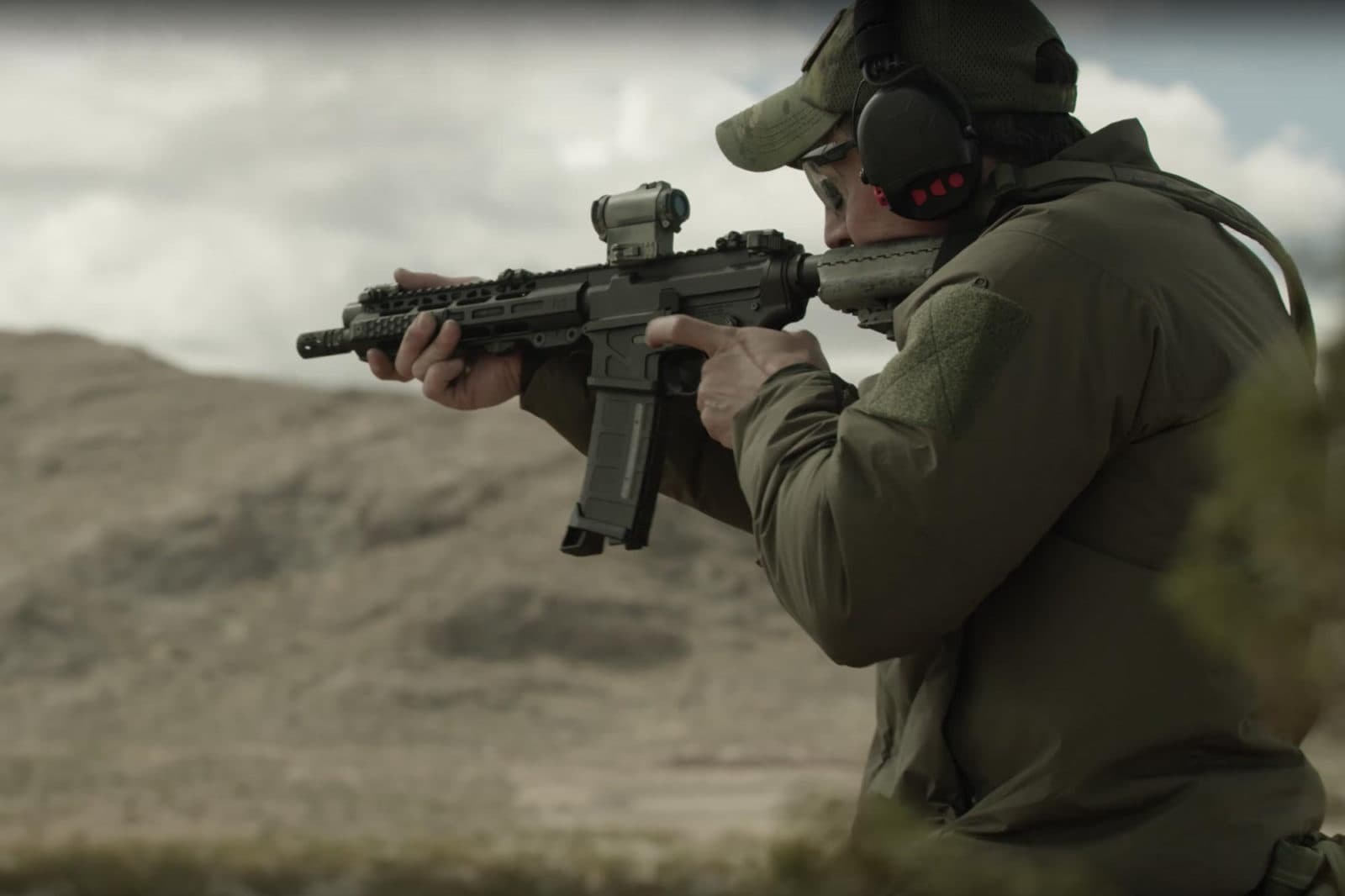 SWAT officer aiming rifle in desert