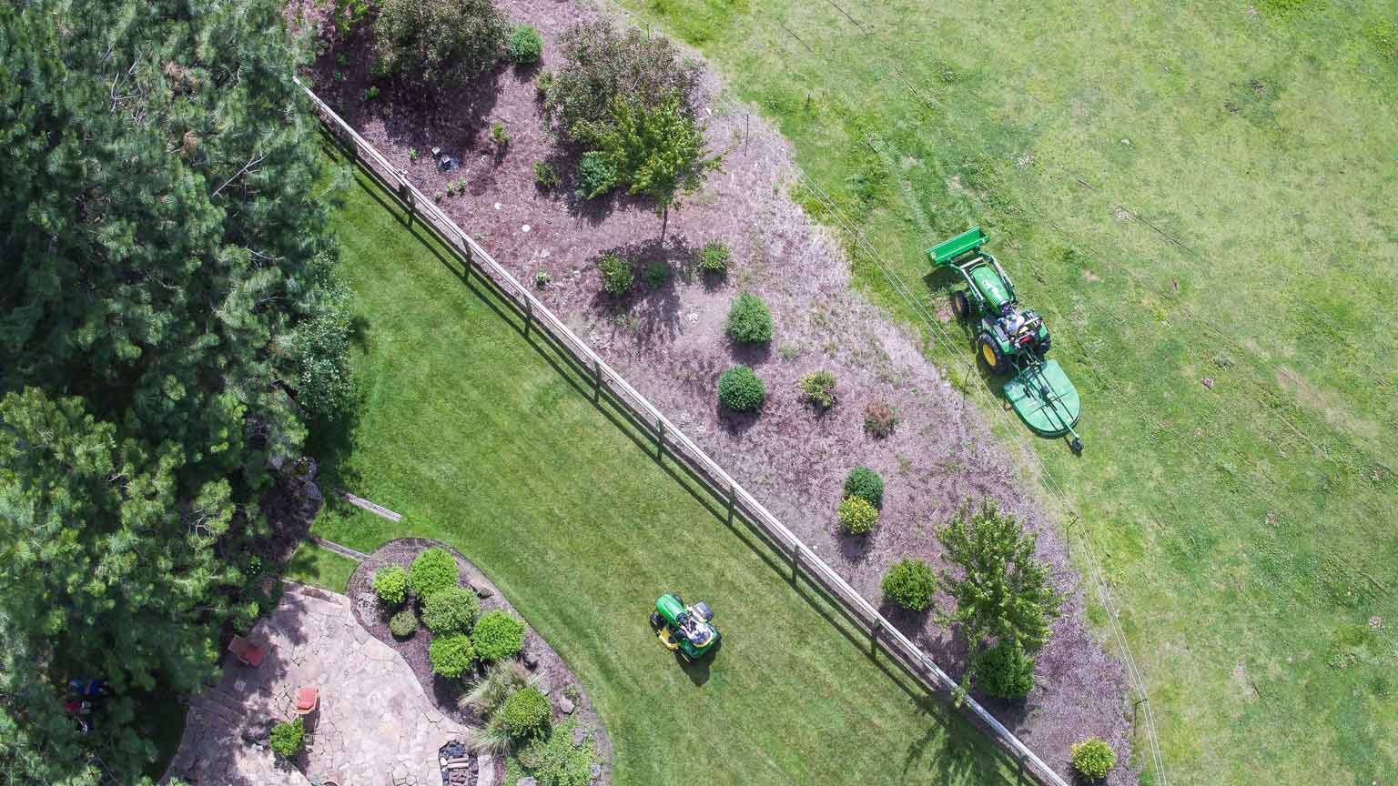 Aerial of mowers on green lawn