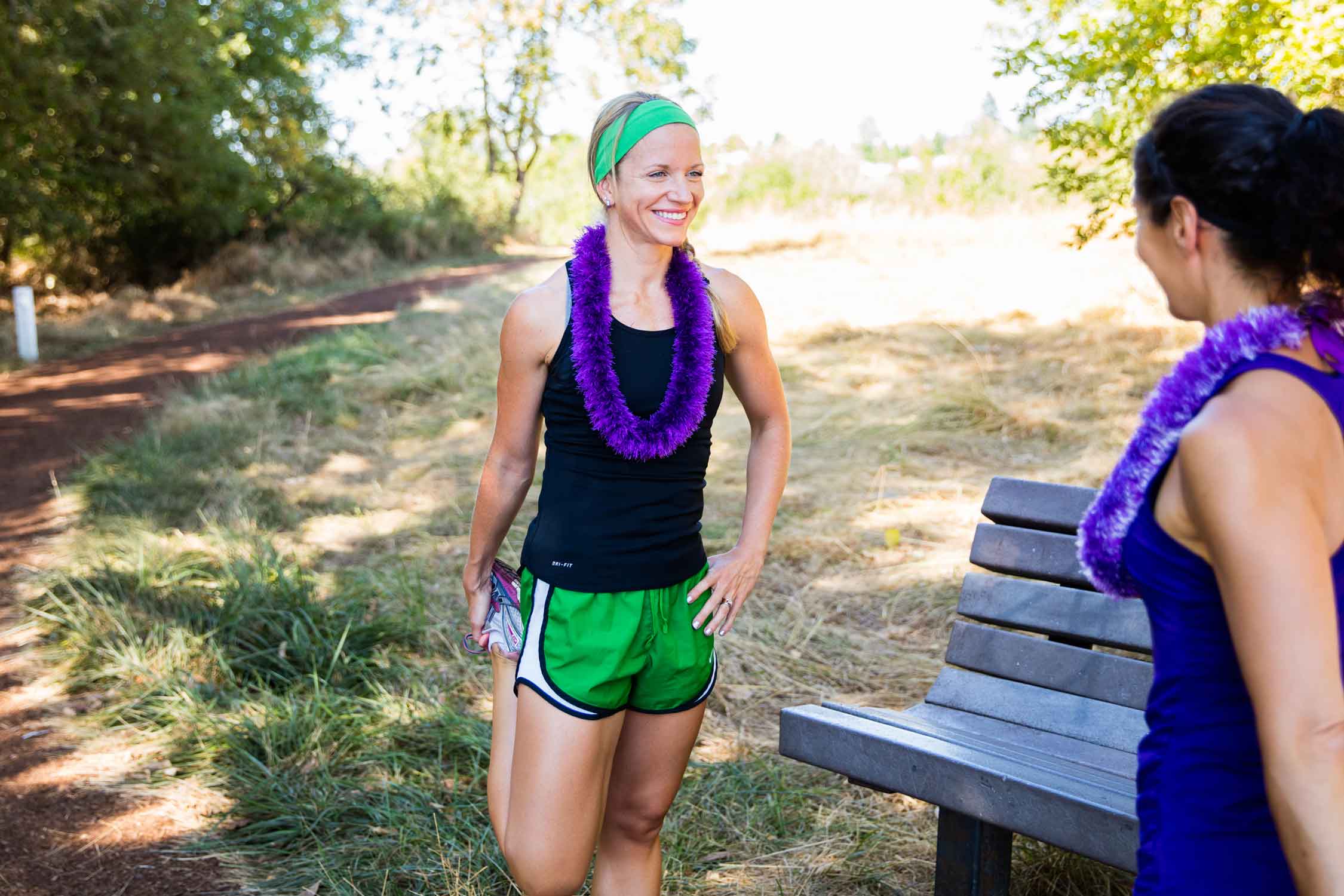 Two runners chatting by park bench