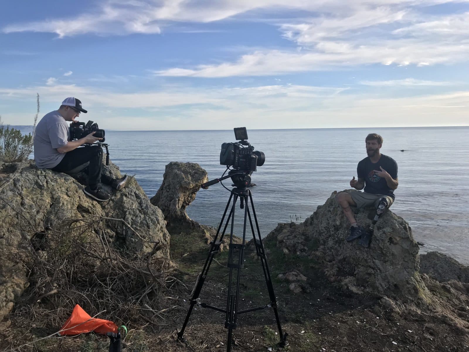 Film crew on coastal rocks