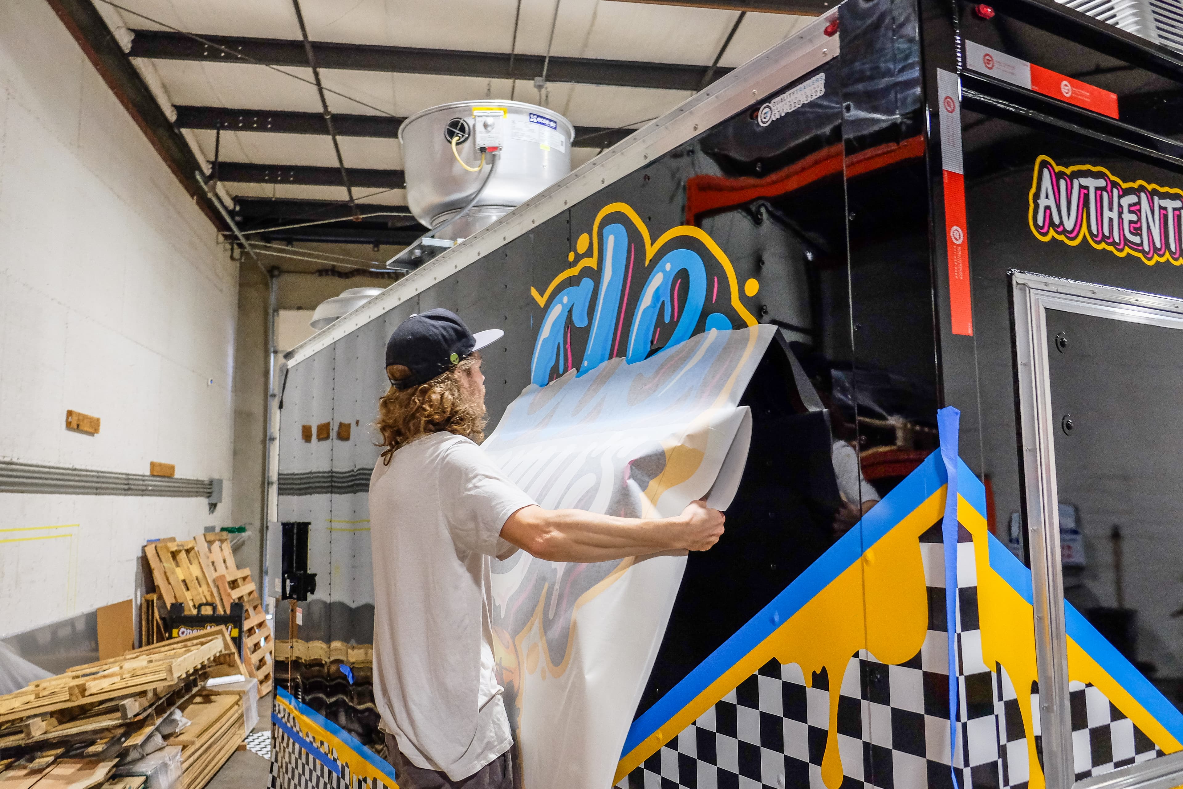 An installer applying a vinyl wrap to a trailer