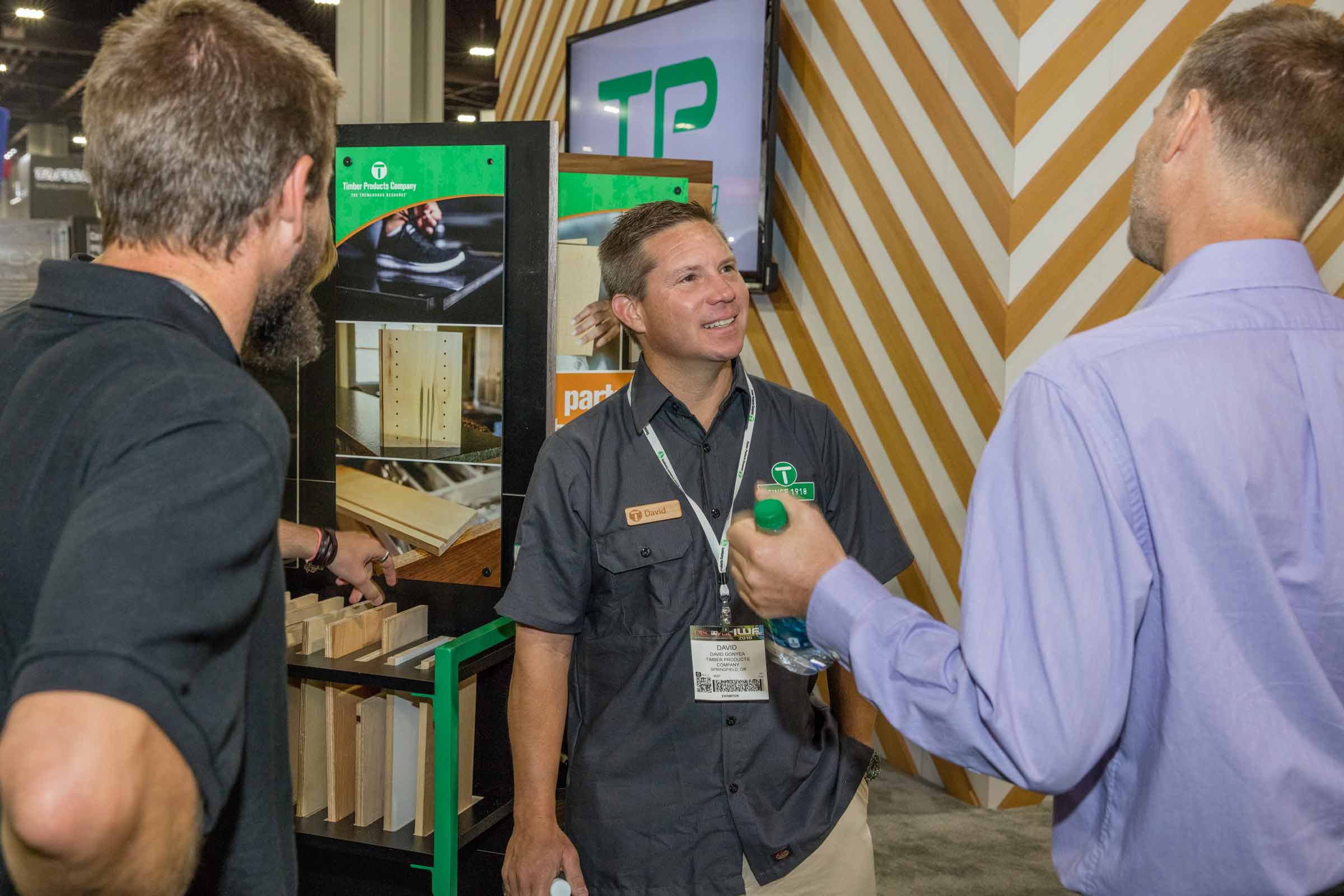 Visitors in conversation at the Timber Products booth at IWF