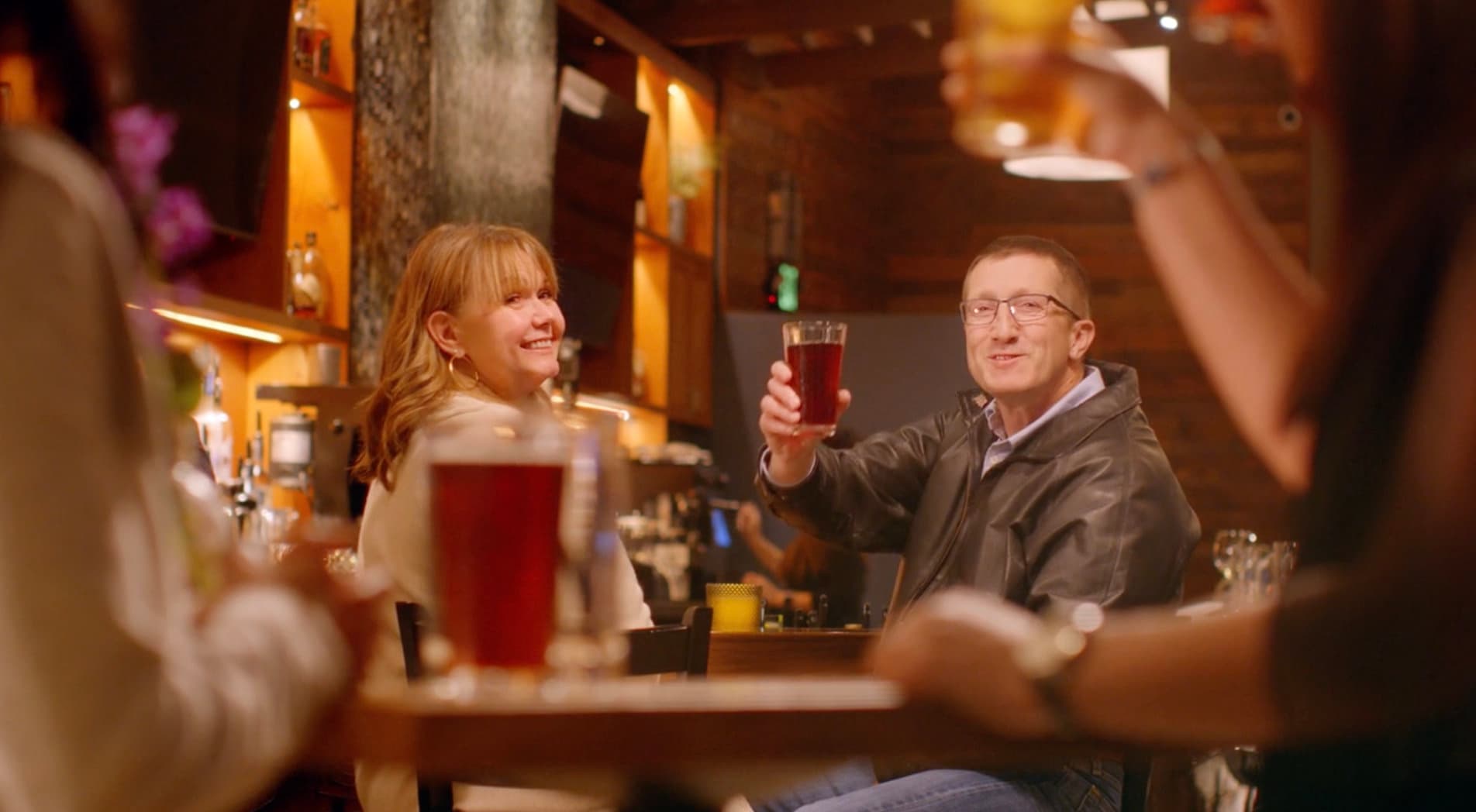 Friends toasting in a warm brewpub, a still from the Braveheart Brewing commercial
