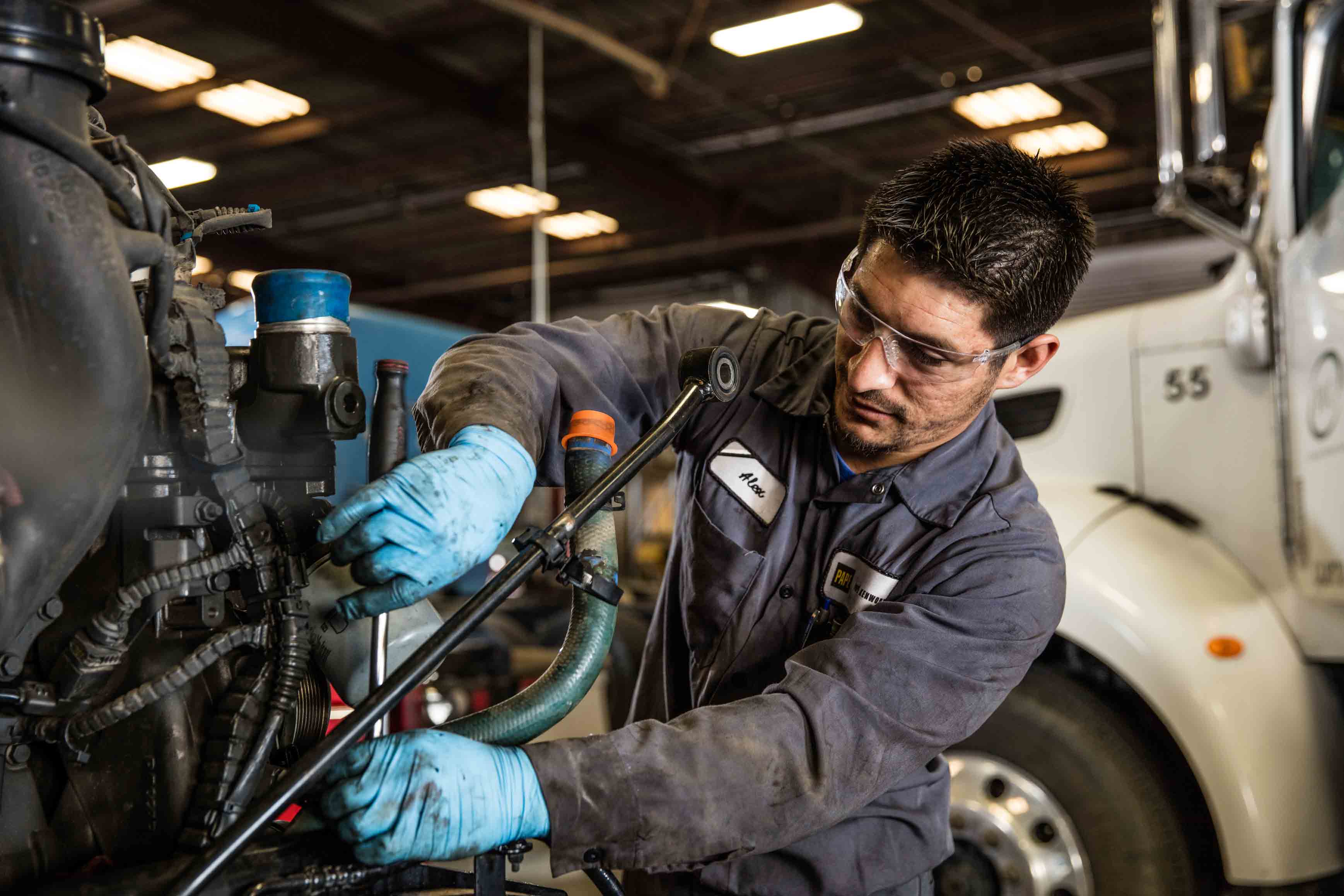 A technician servicing a truck engine, photographed for Papé
