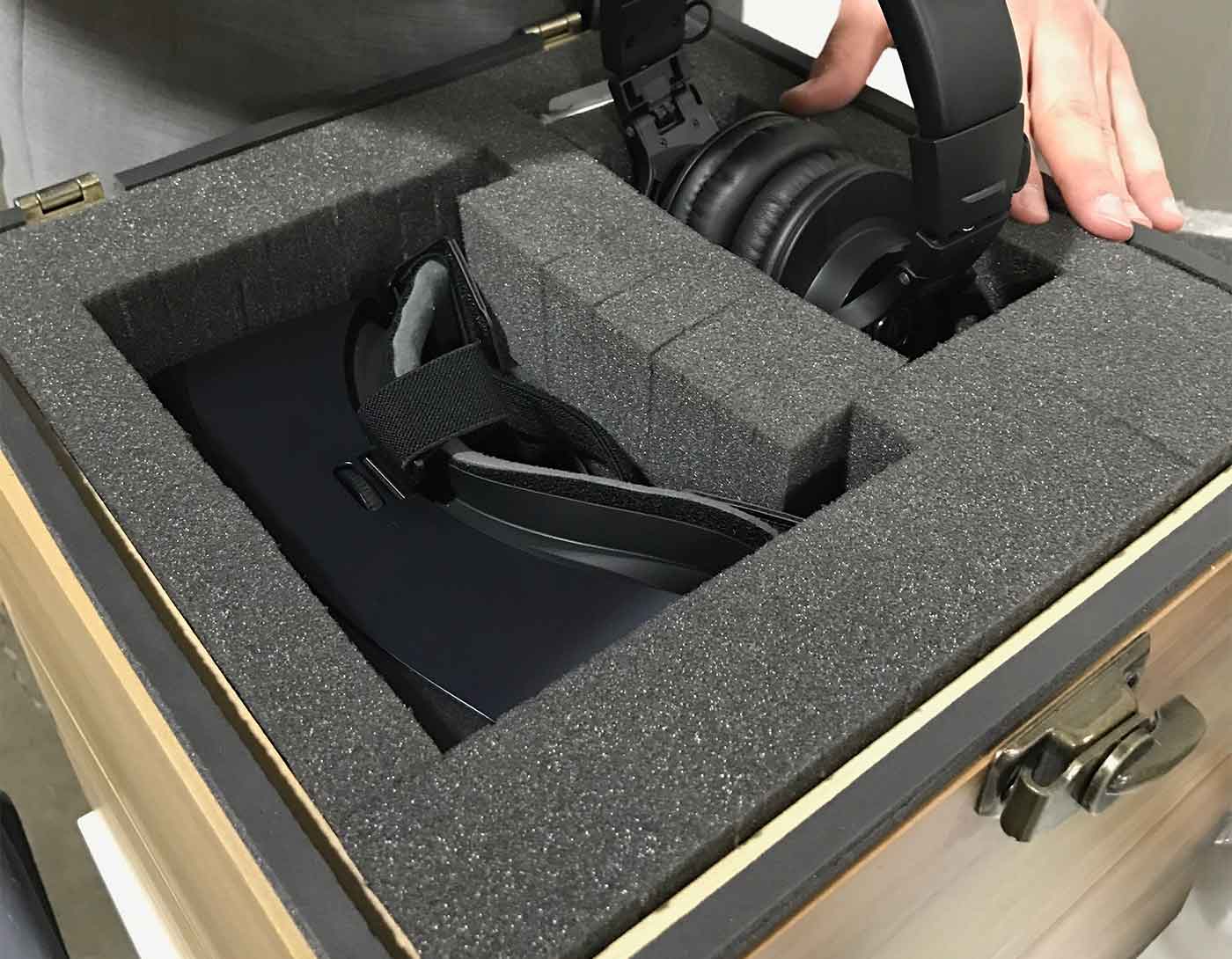 Headphones being packed into a custom foam case